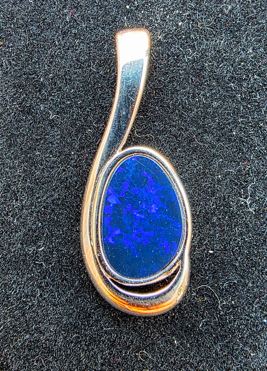 Silver pendant with a blue stone on a black background