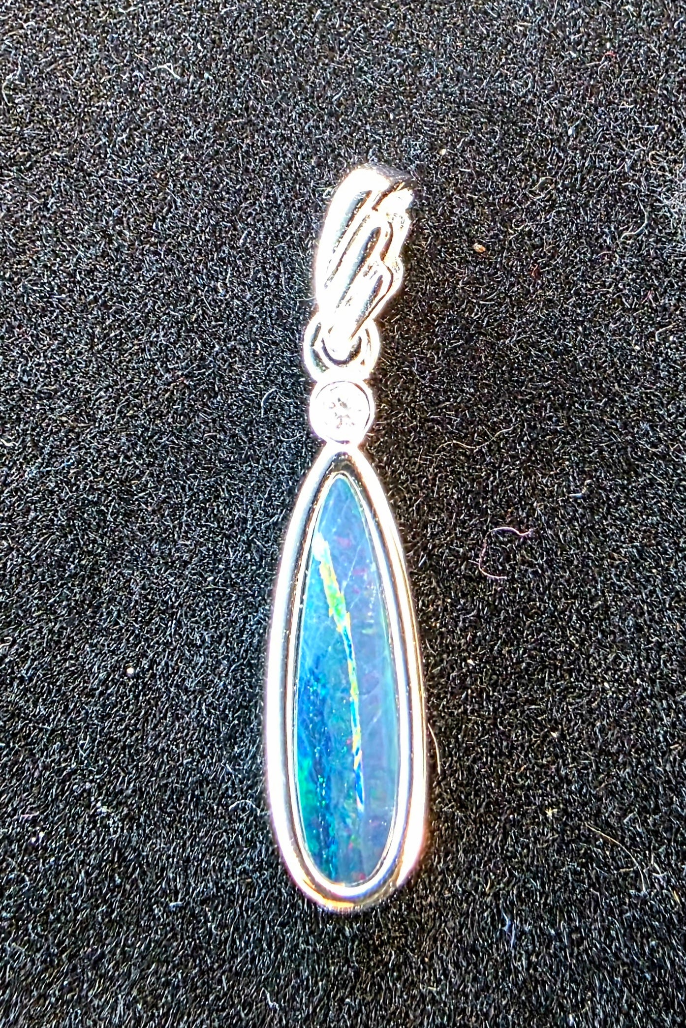 Opal pendant with silver setting on a dark background