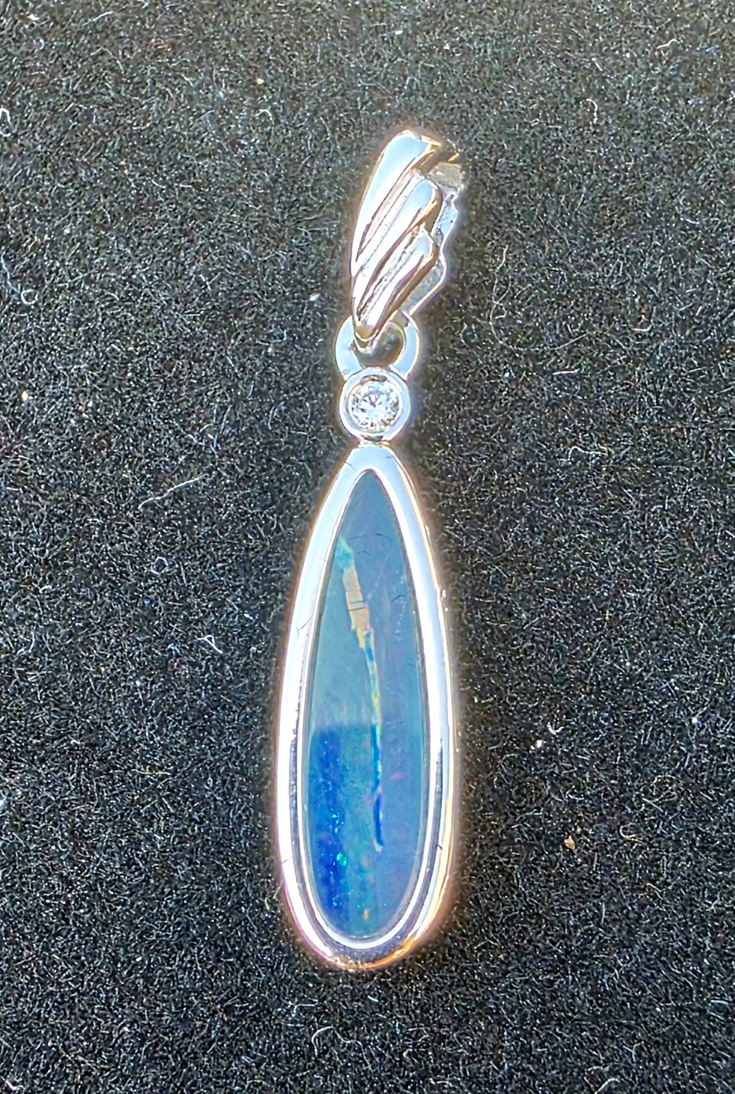 Opal pendant with silver setting on a dark background
