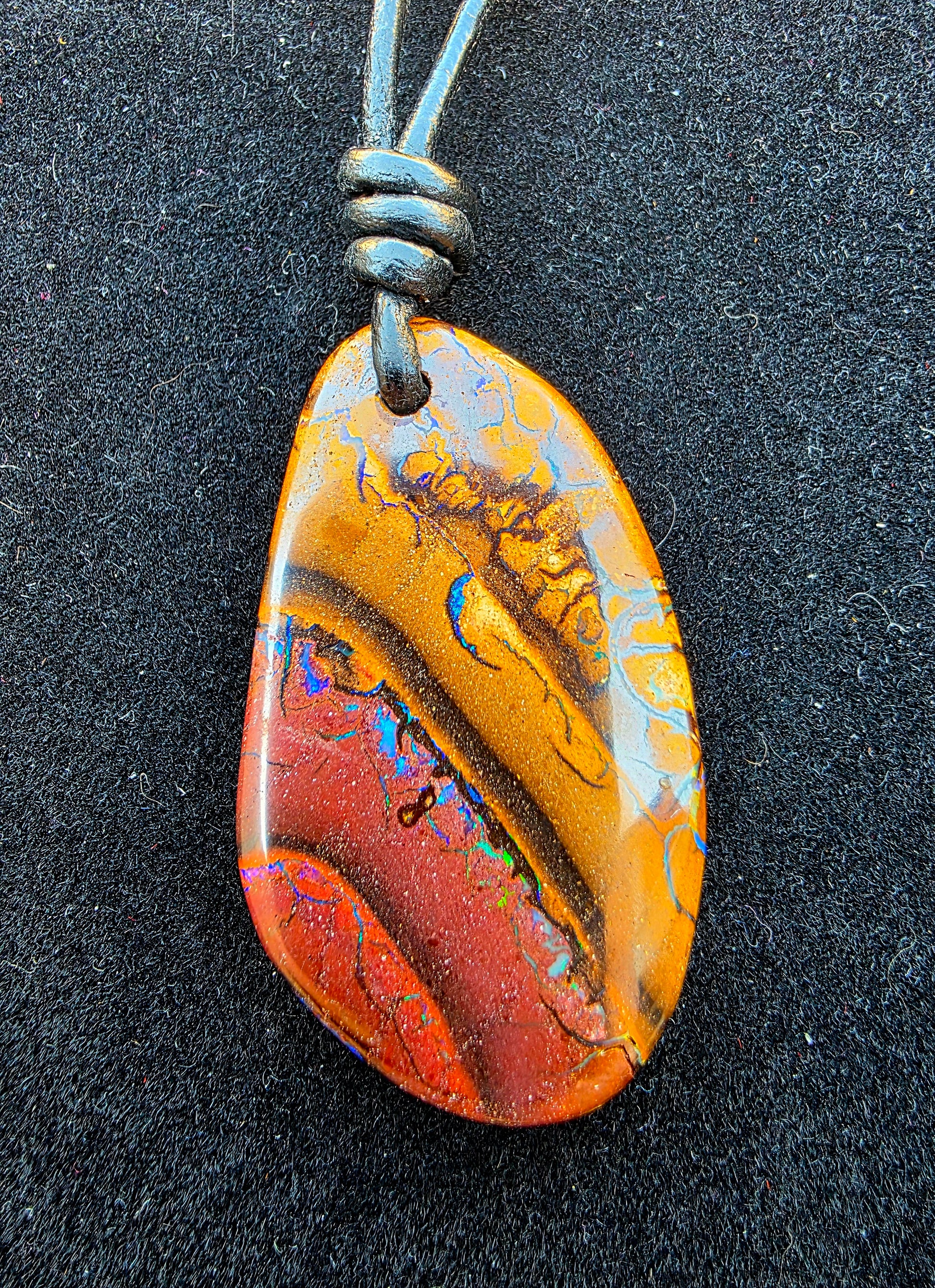 Multicoloured stone pendant on a black background
