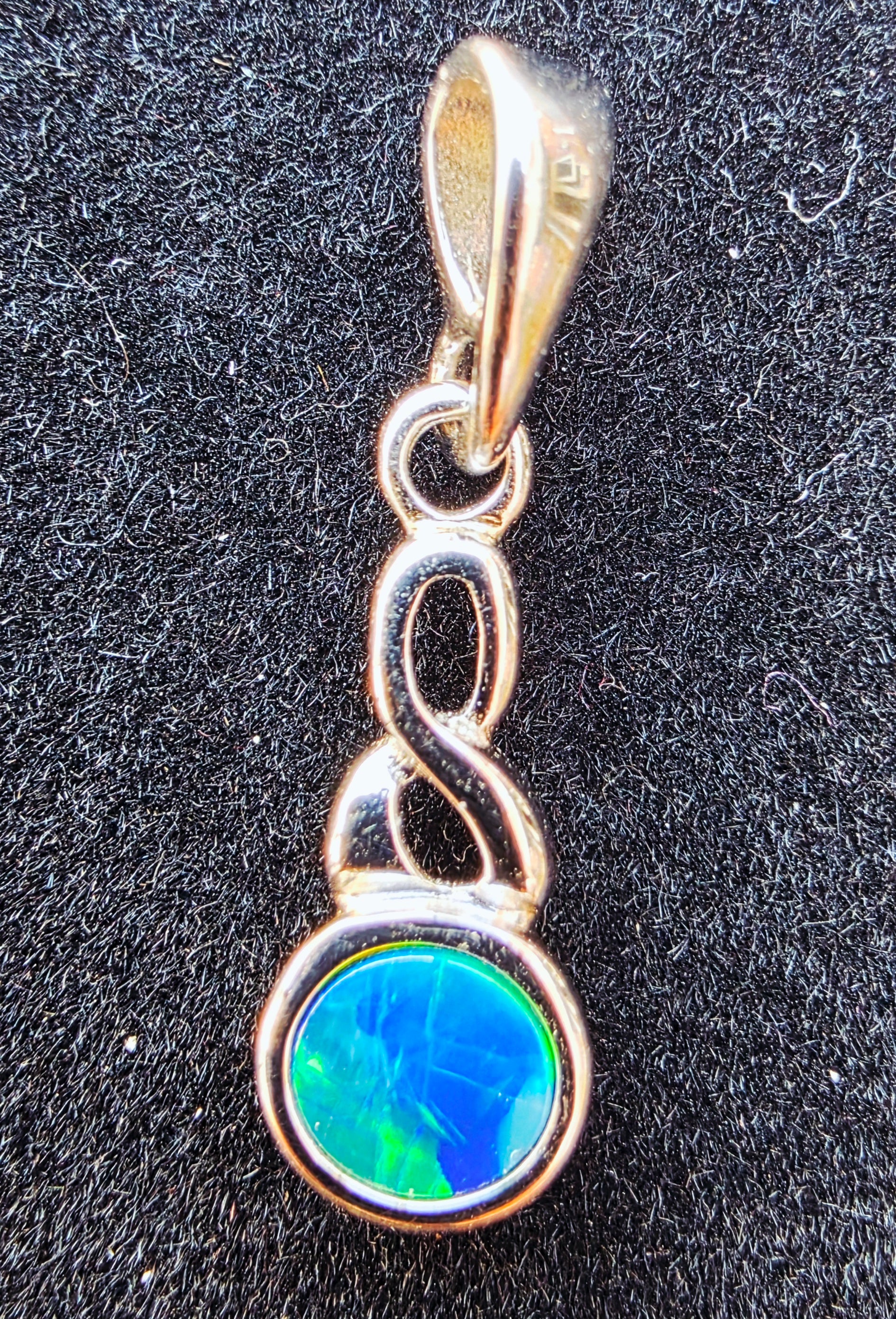 Pendant with a green gemstone on a black background