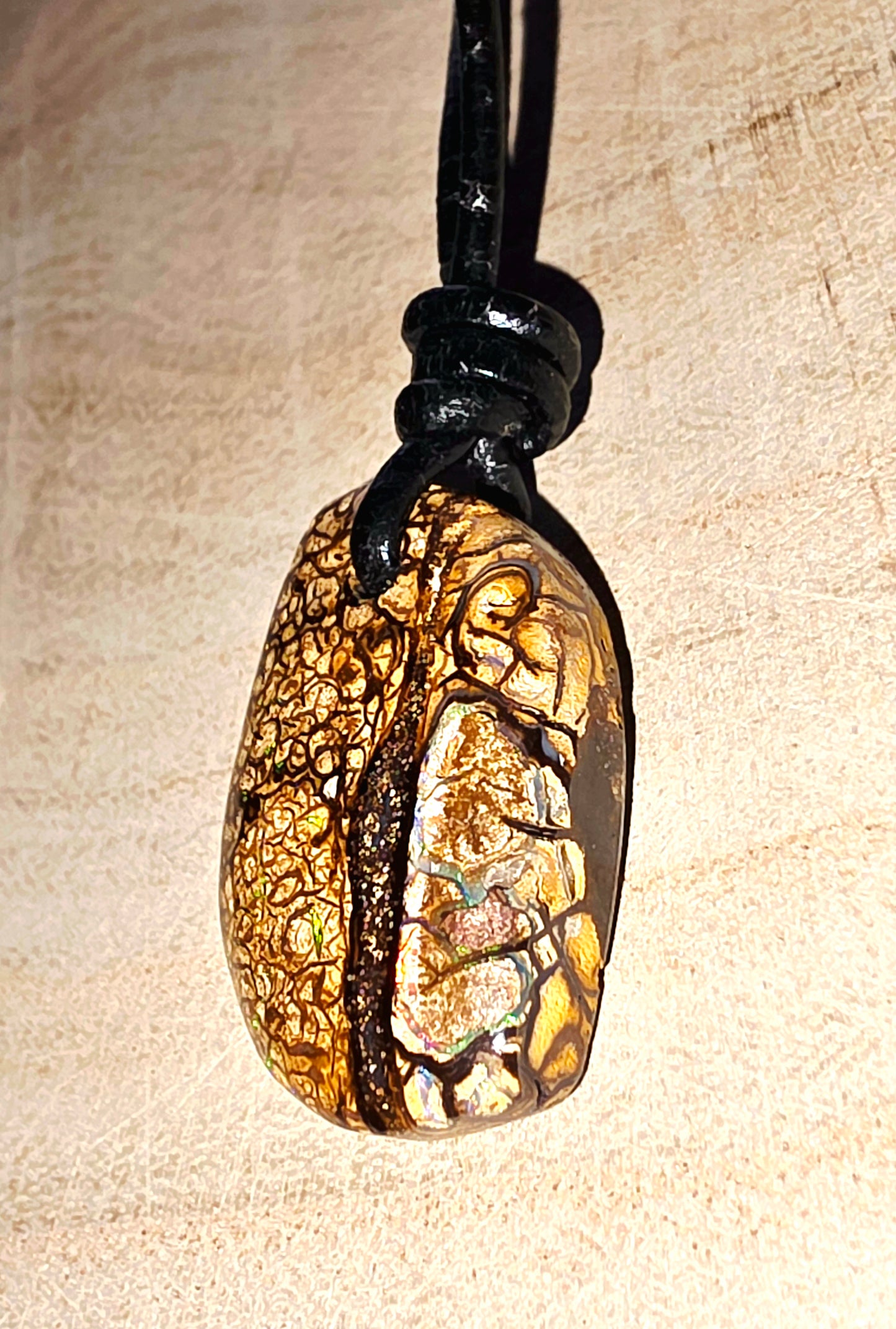 Necklace with a textured pendant on a beige background