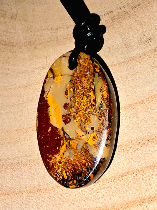 Oval-shaped pendant with a natural pattern on a beige background