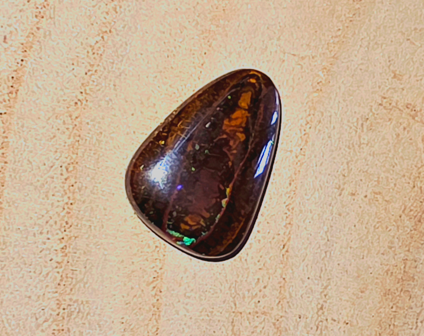 Polished brown stone on a beige textured background