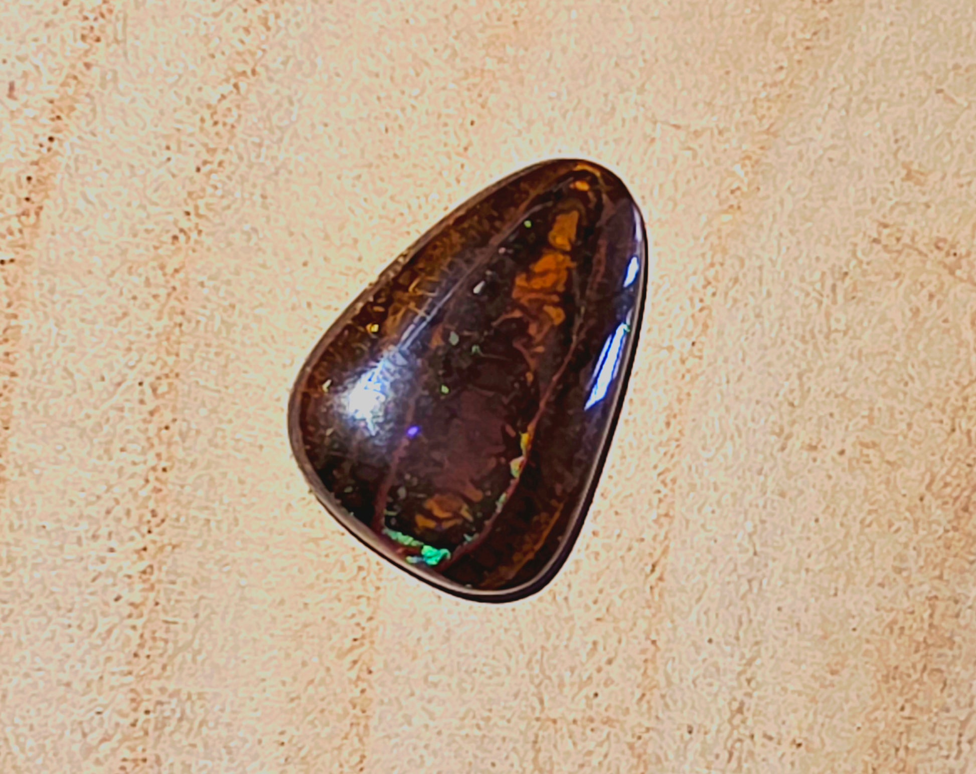 Polished brown stone on a beige textured background