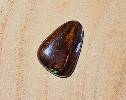 Polished brown stone on a beige textured background
