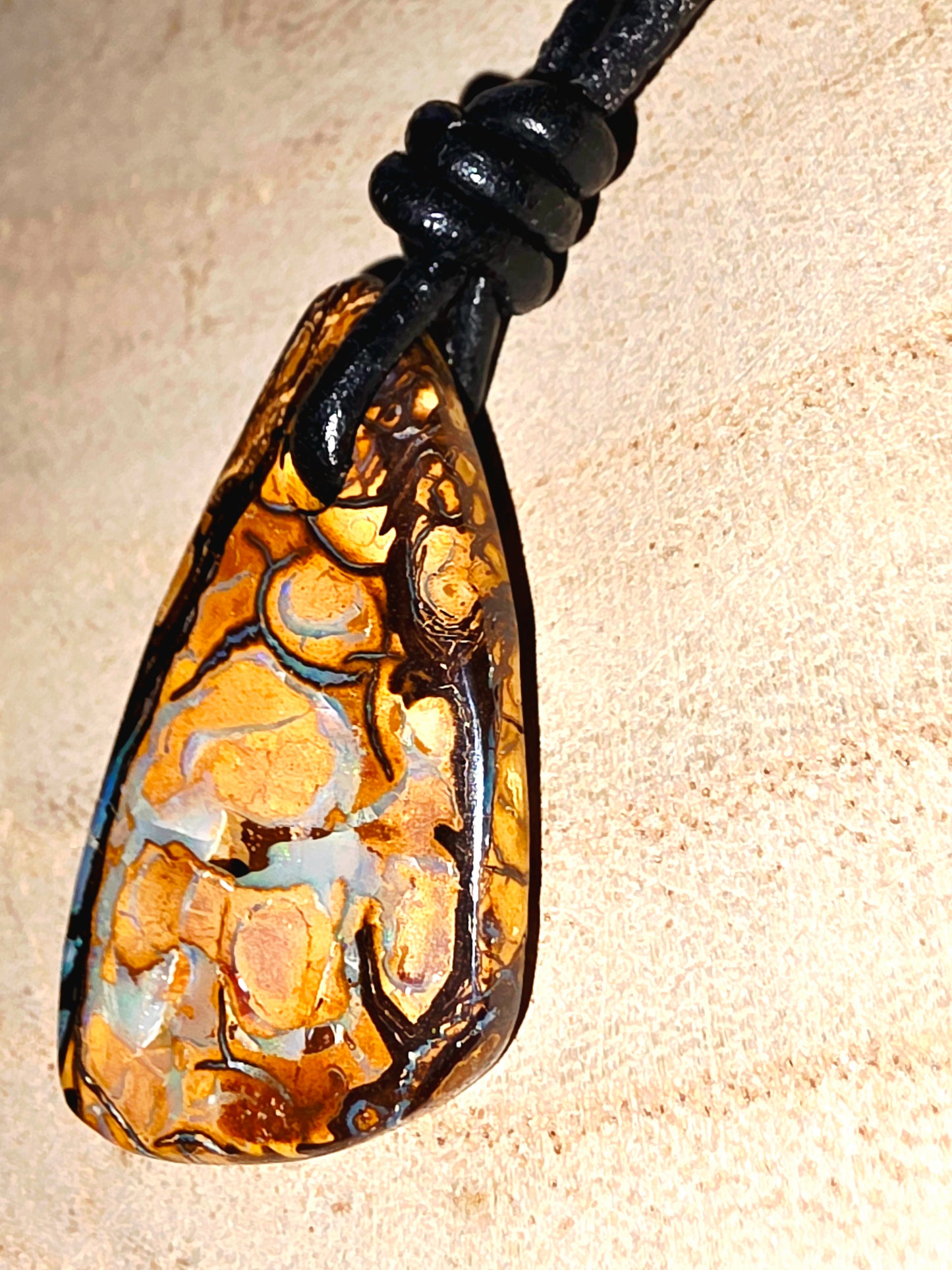 Jewellery pendant with intricate design on a beige background