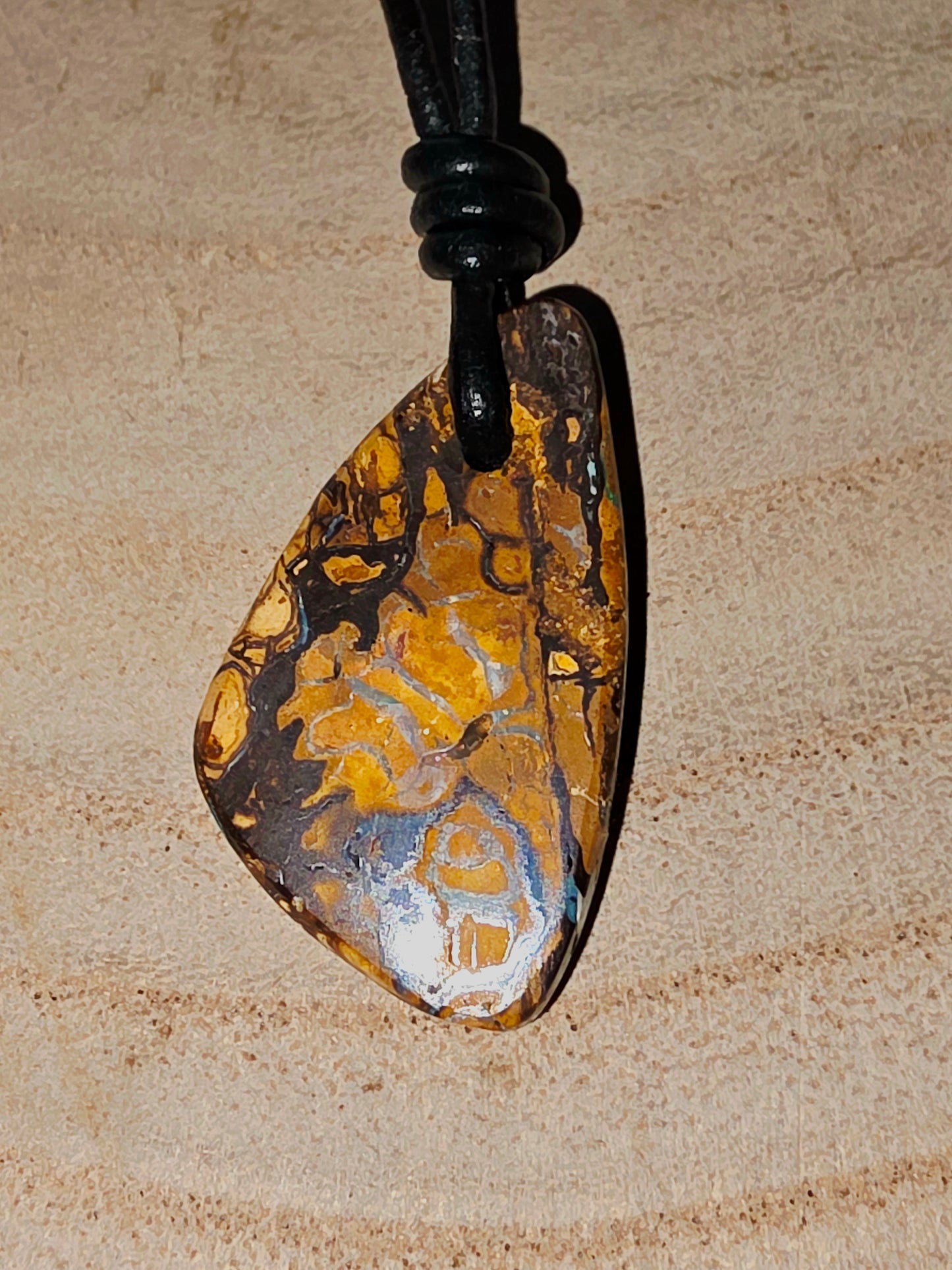 Pendant with a textured opal design on a beige background