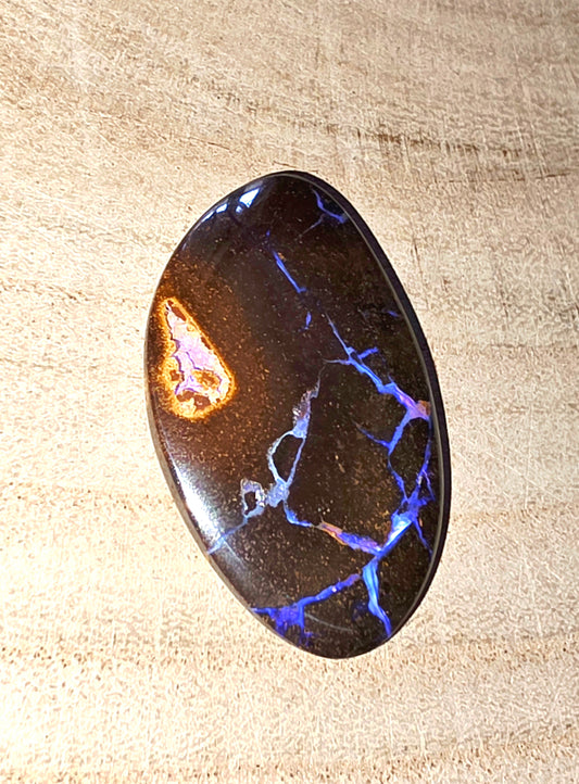 Polished stone with blue and purple vein patterns on a beige background