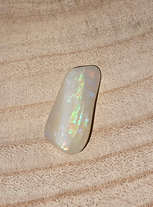 Opal stone on a textured beige surface