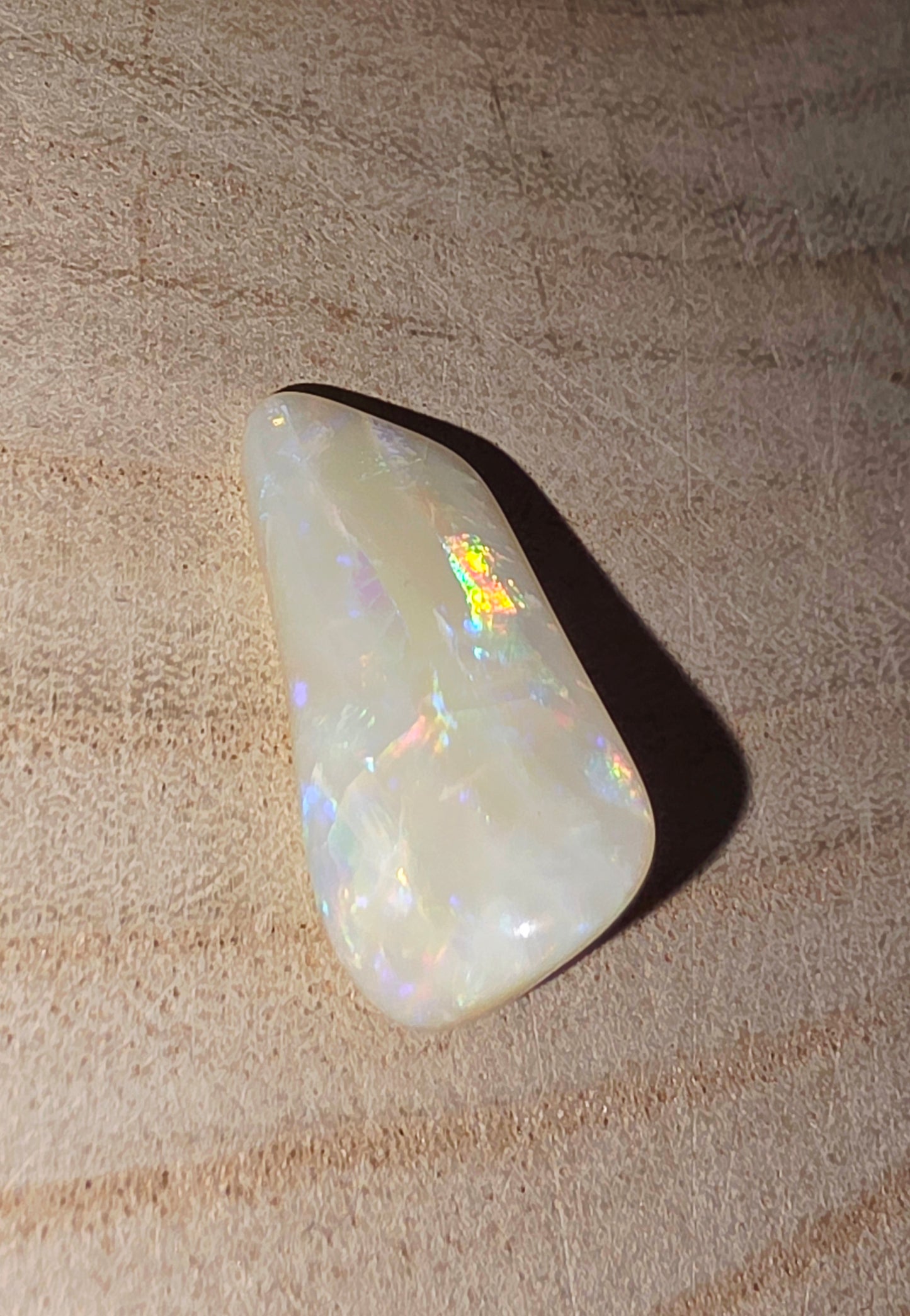 Opal stone on a textured beige surface