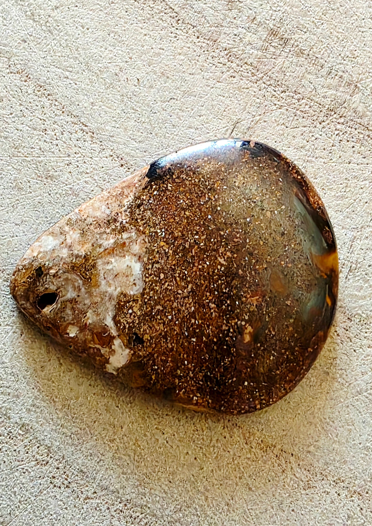 Brown and white stone on a textured beige surface