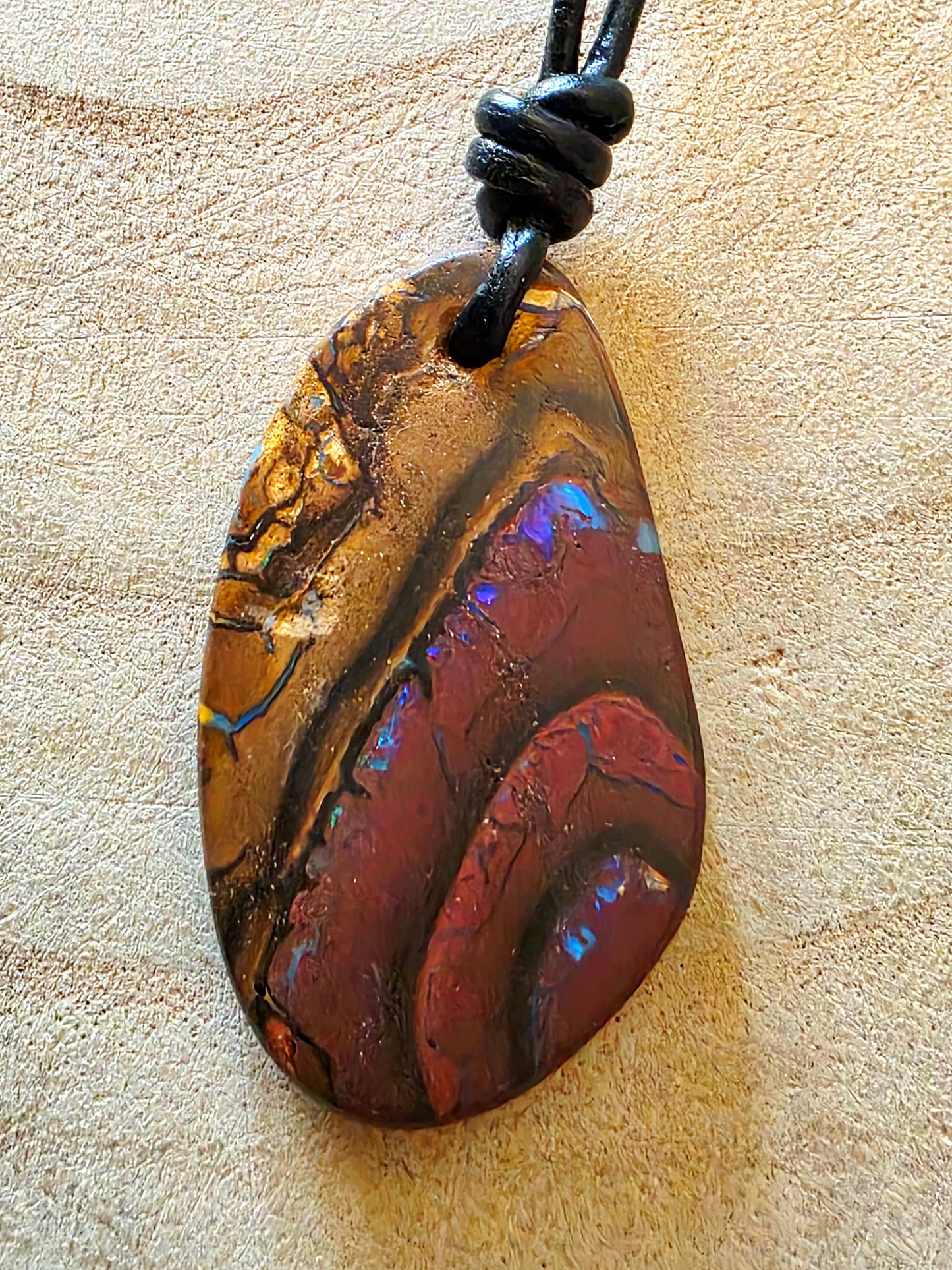 Multicoloured stone pendant on a beige background