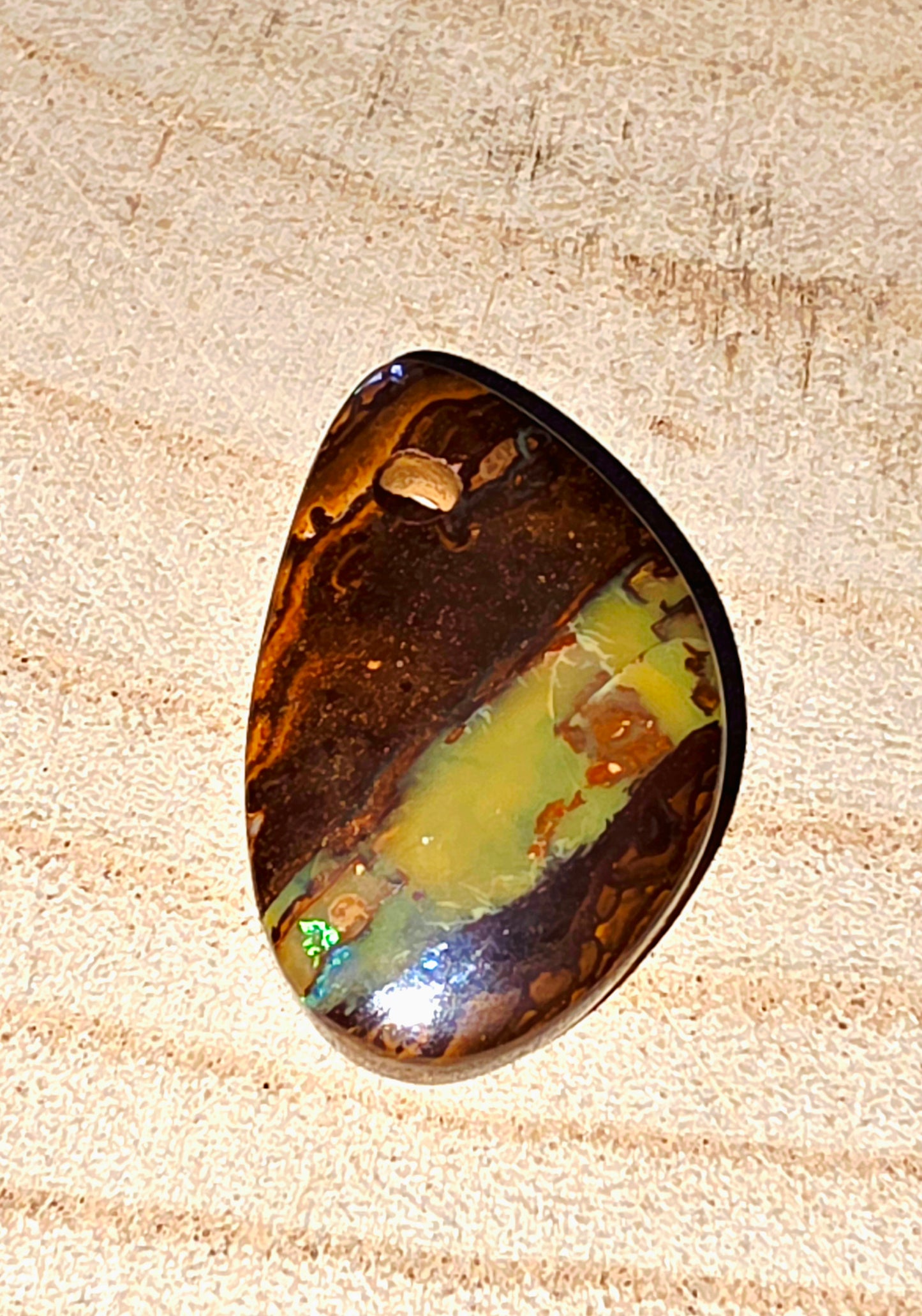 Polished opal stone on a wooden surface
