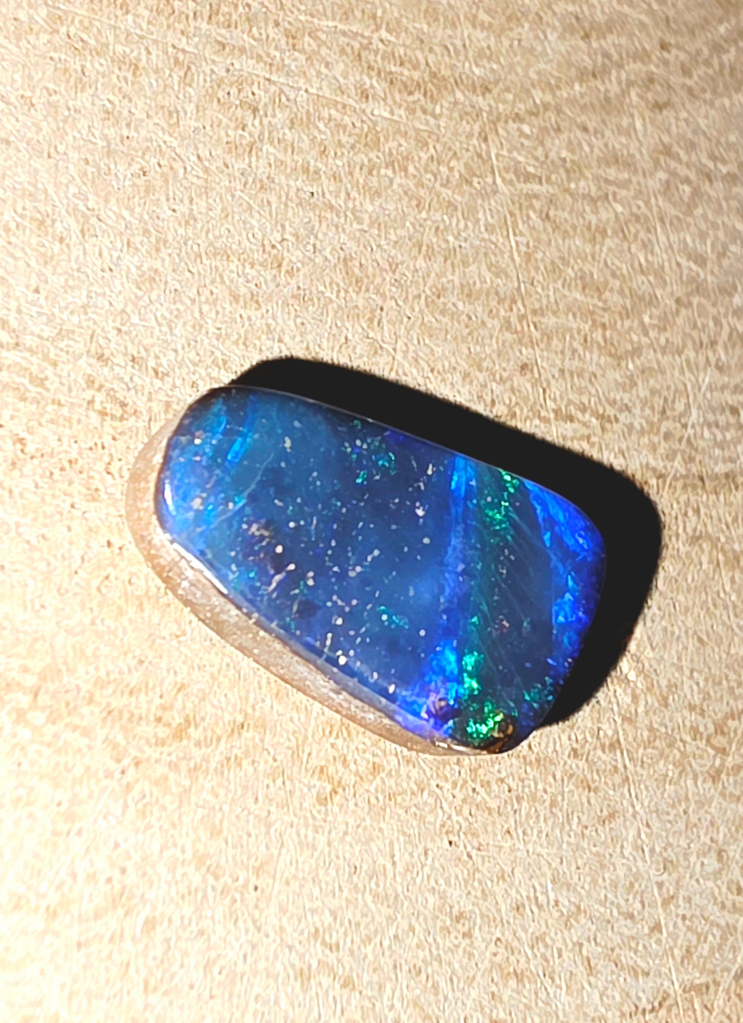Blue opal stone on a beige background