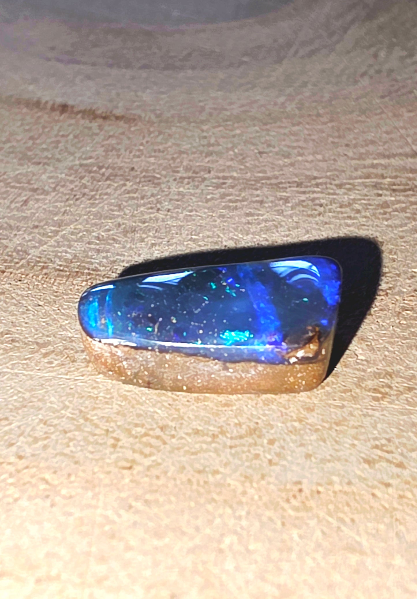 Blue gemstone on a beige wood background