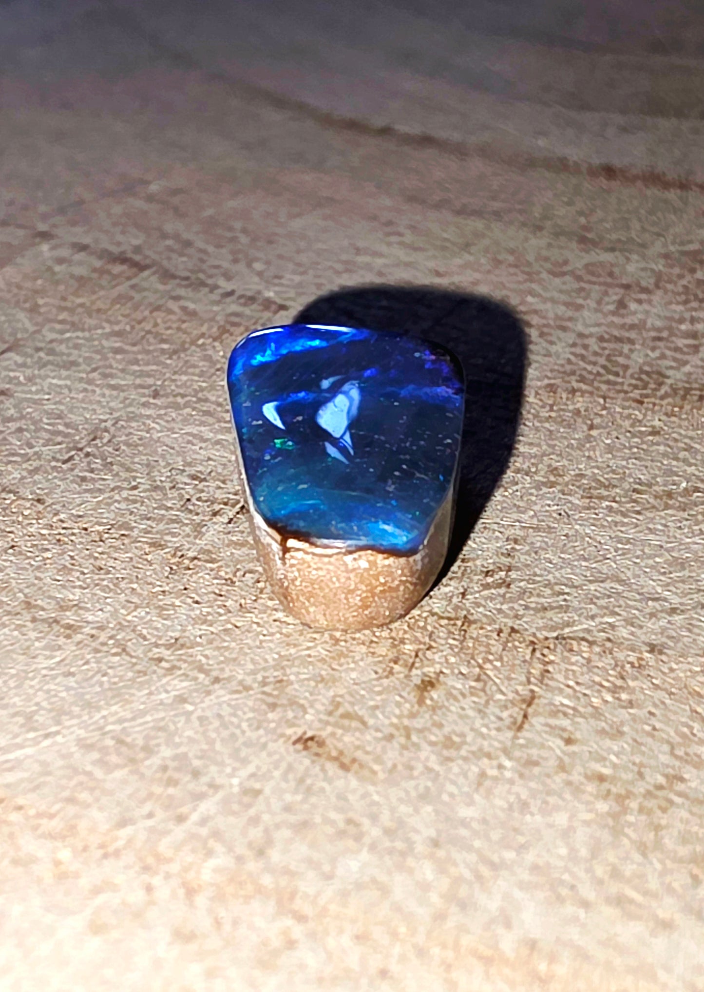 Blue opal gemstone on a beige surface