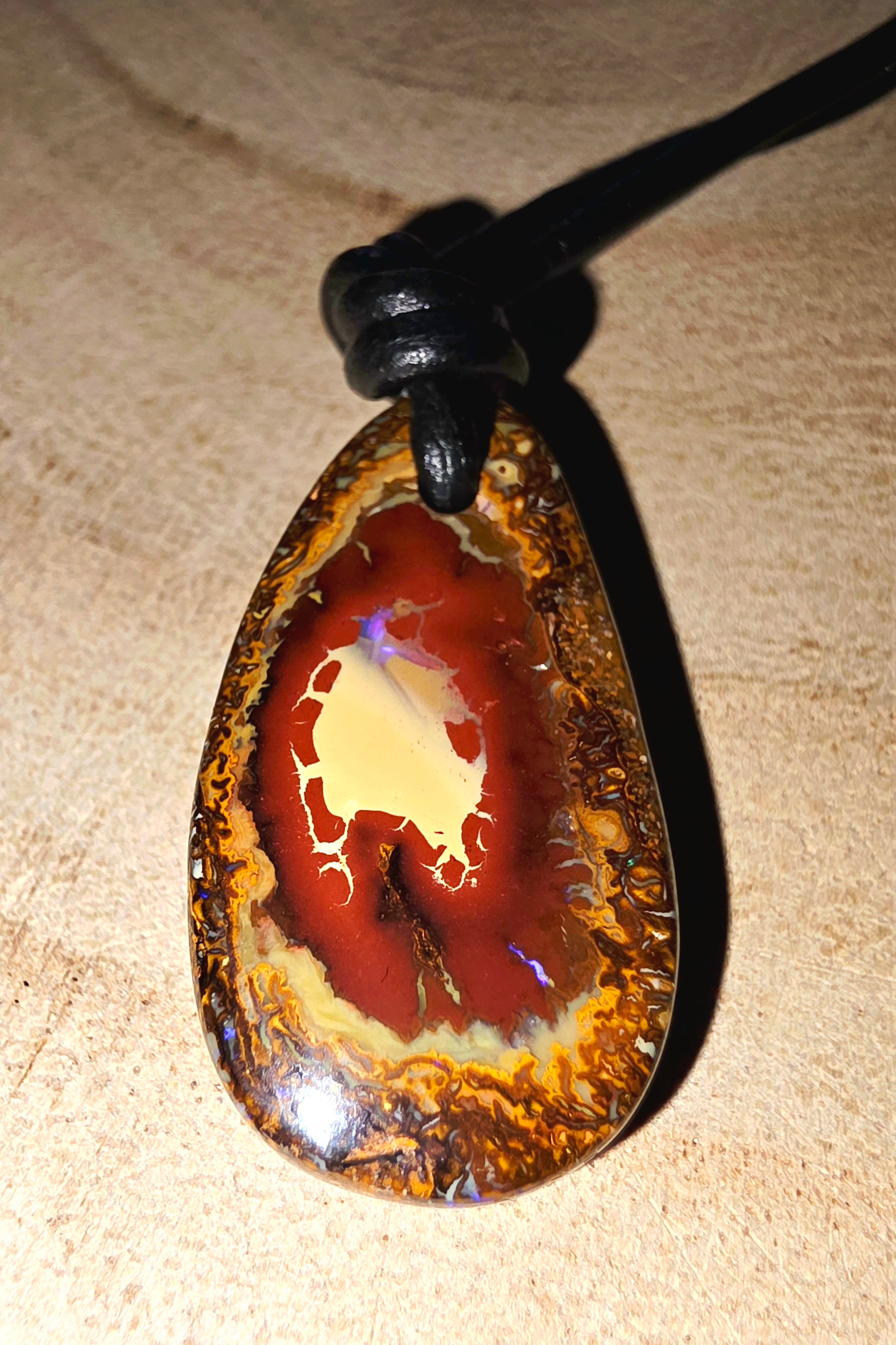 Opal pendant on a beige surface