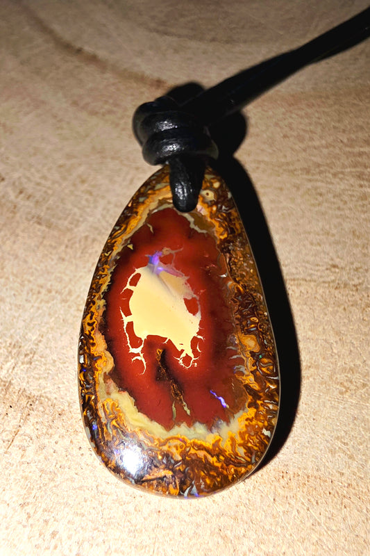Opal pendant on a beige surface