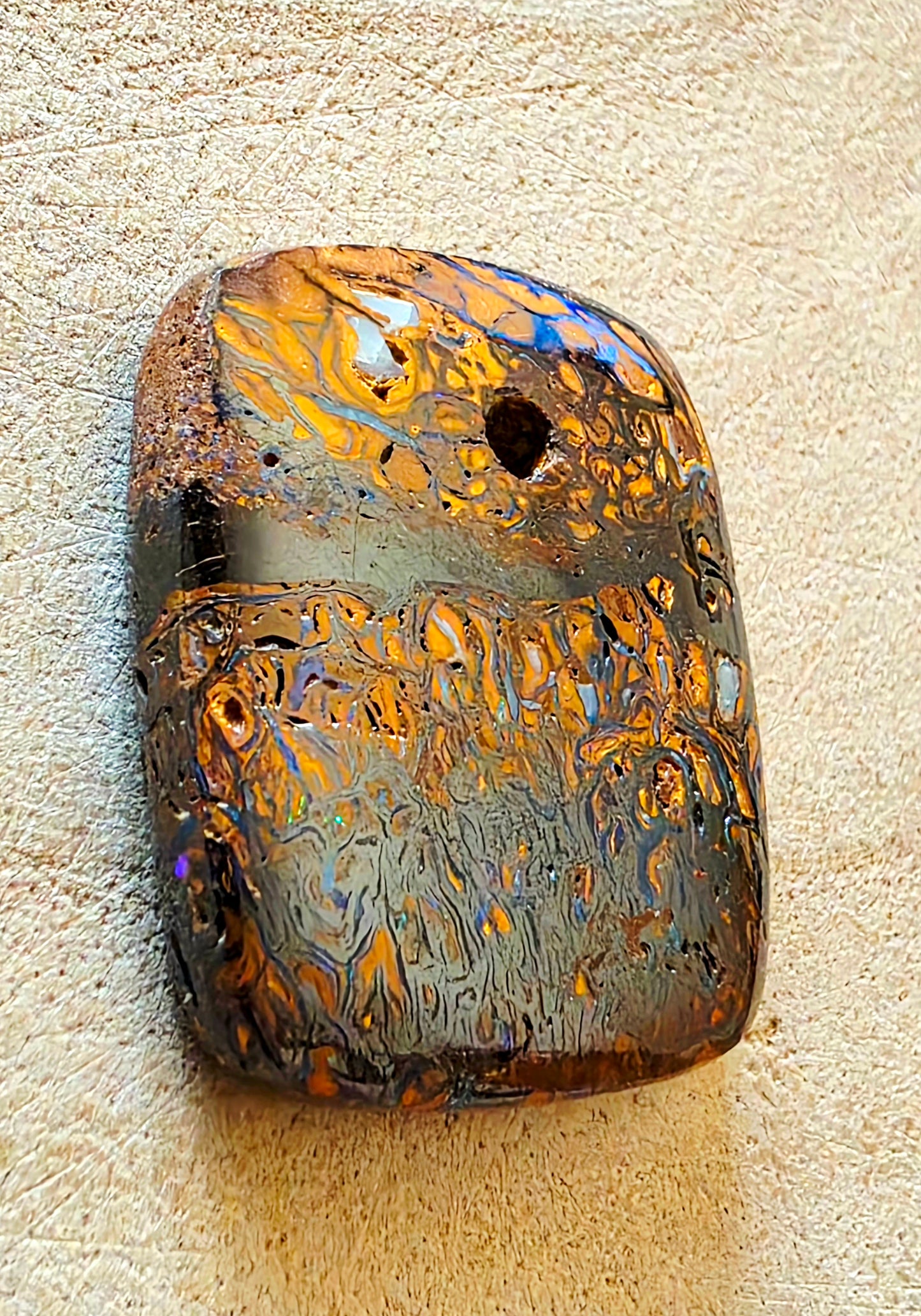 Opal stone with colourful patterns on a beige background