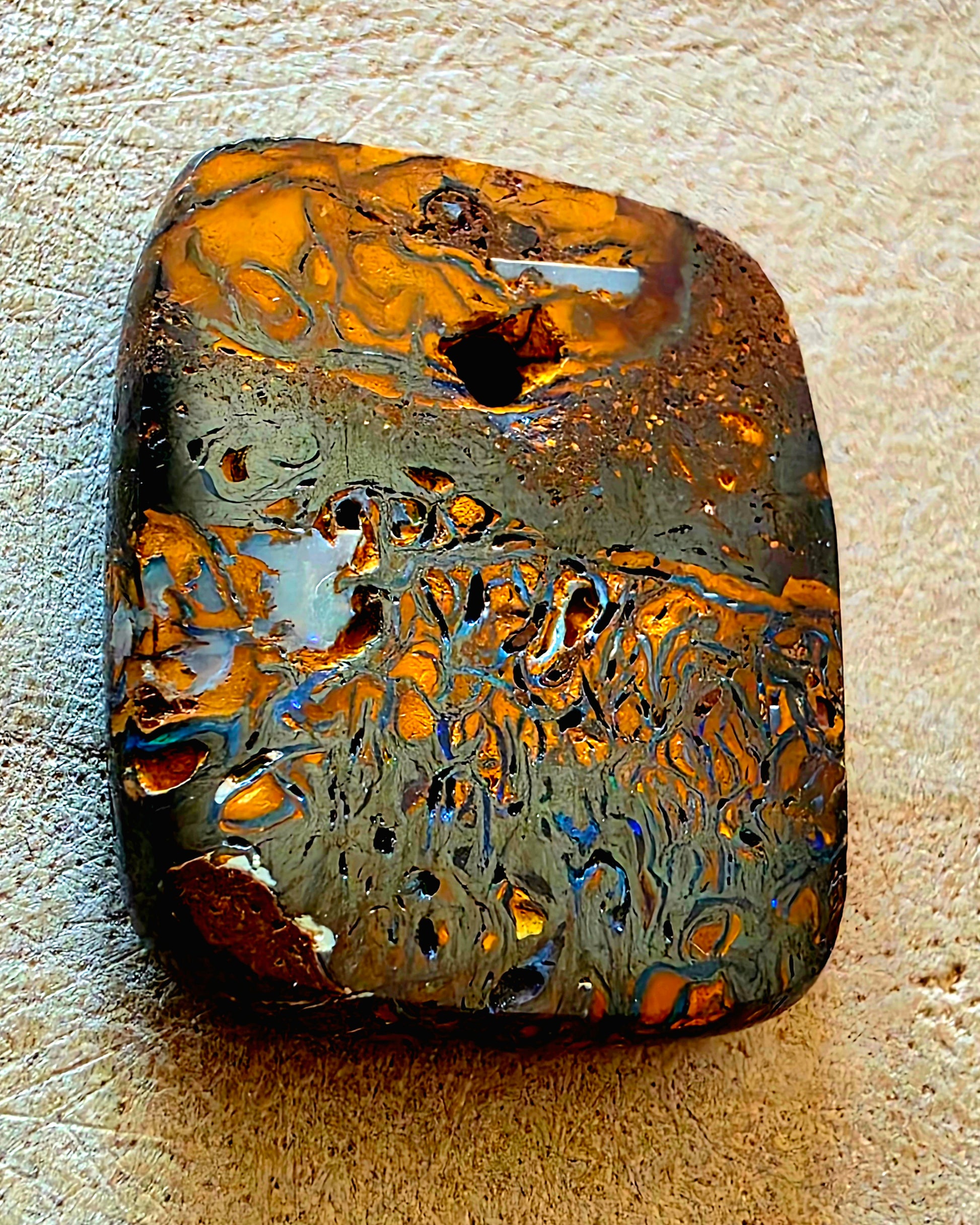 Polished stone with marbled pattern on a beige surface