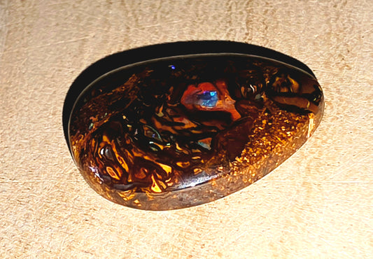 Tortoiseshell-patterned boulder opal on a beige background