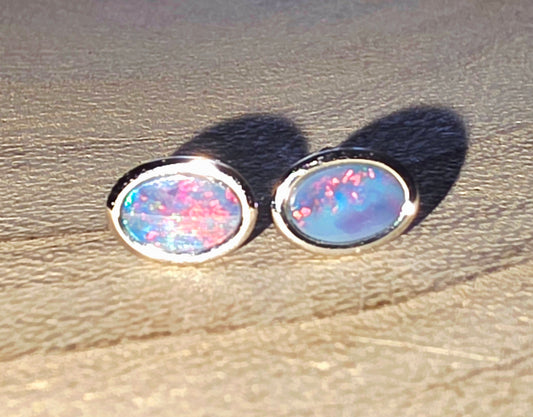 Opal stud earrings on a textured surface