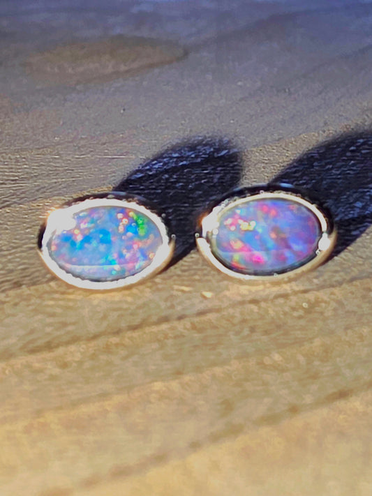 Opal stud earrings on a wooden surface