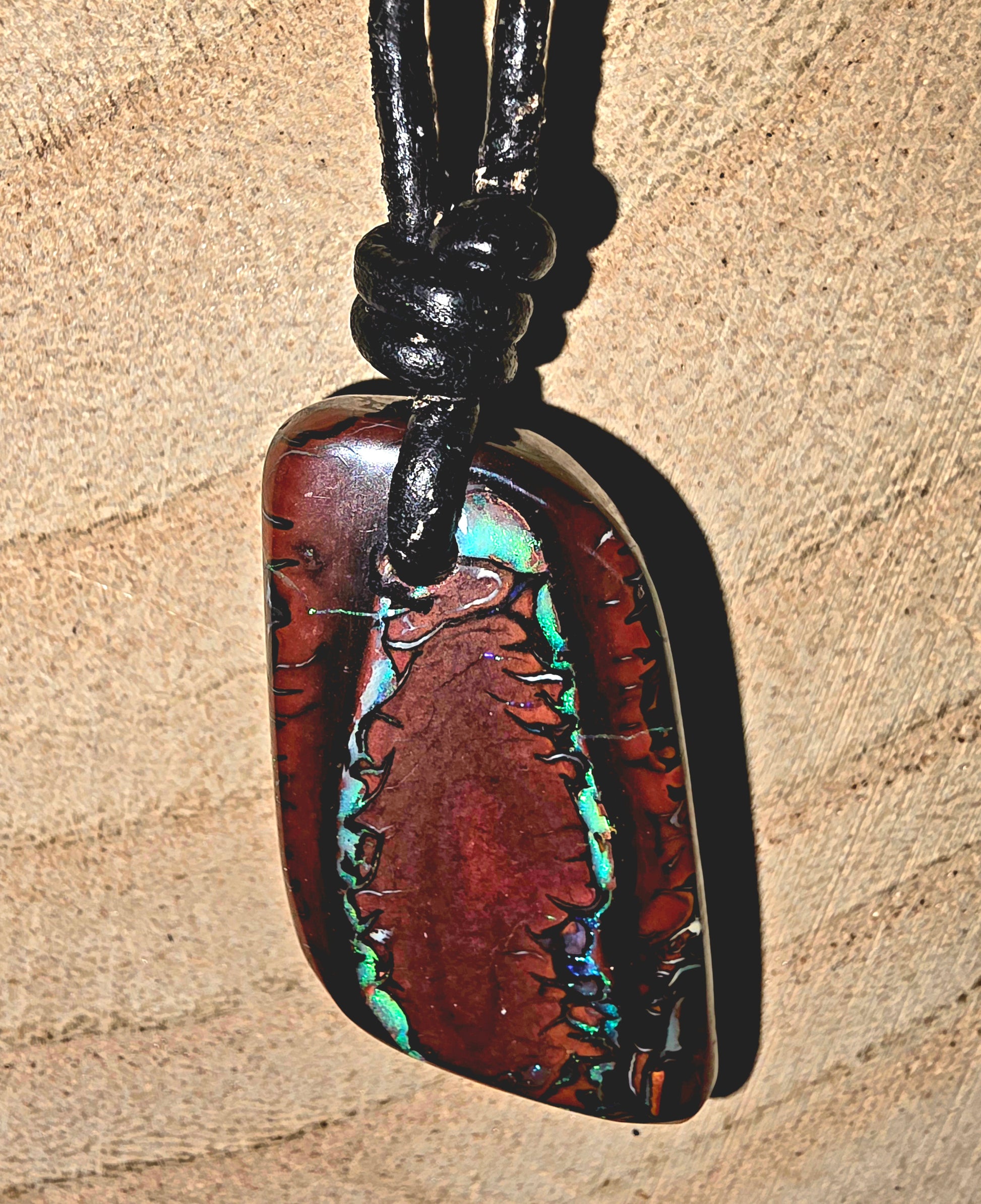 Drilled Boulder Opal Necklace – Blue, Green & Purple Flash on beige surface