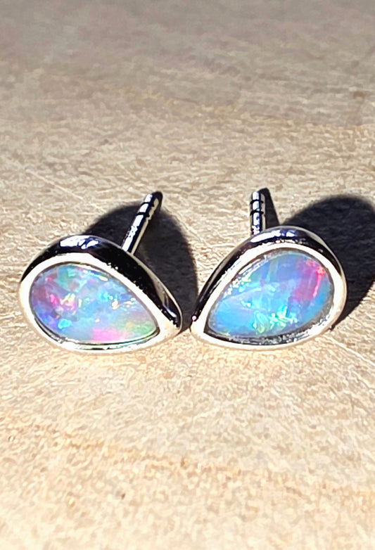 Opal stud earrings on a beige surface