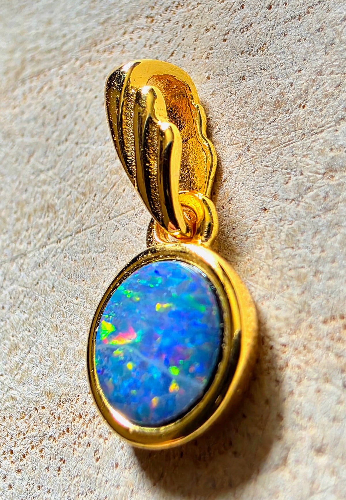 A bright gold multicoloured opal in bezel setting