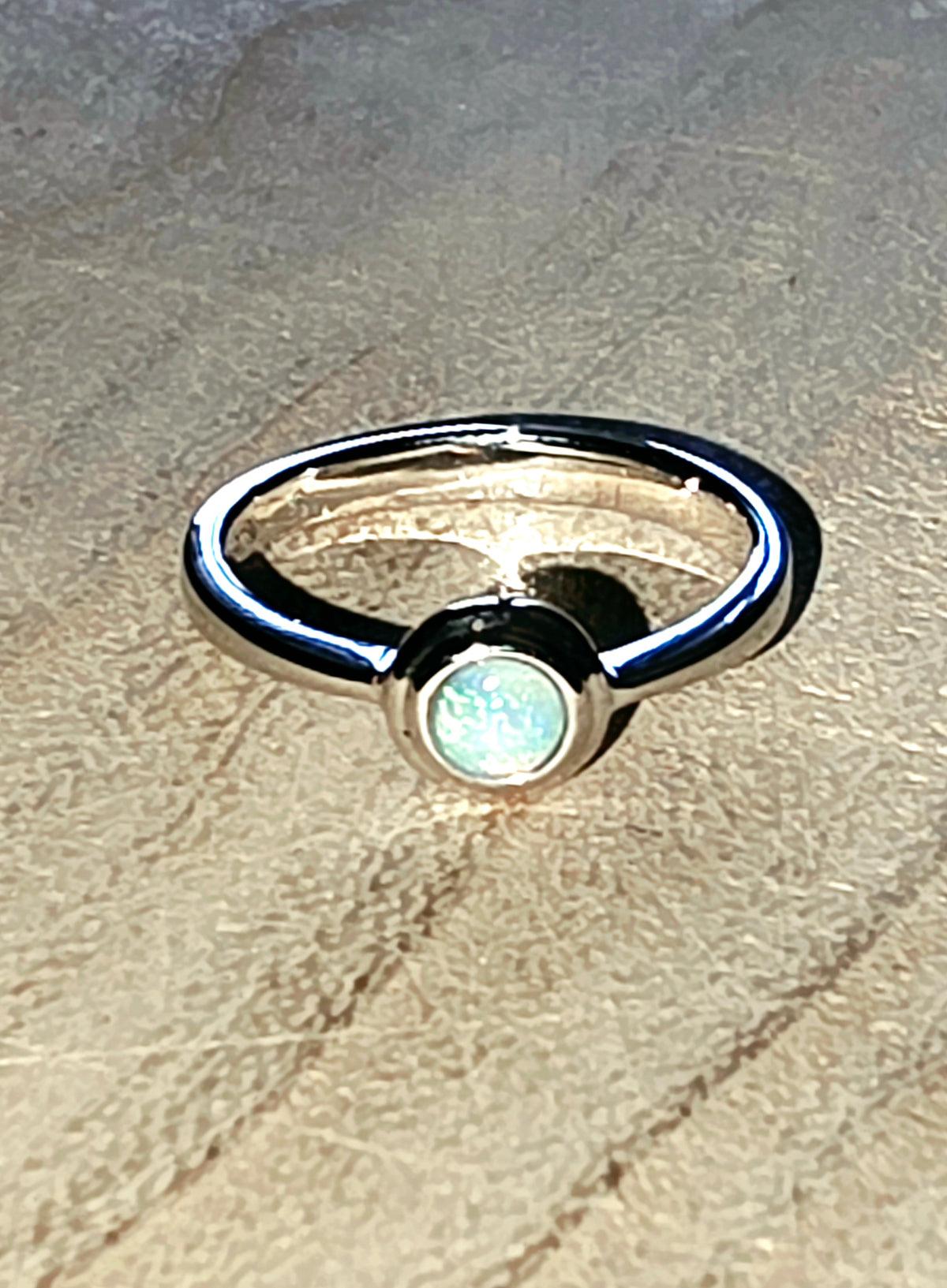 A silver stacker ring with a crystal opal