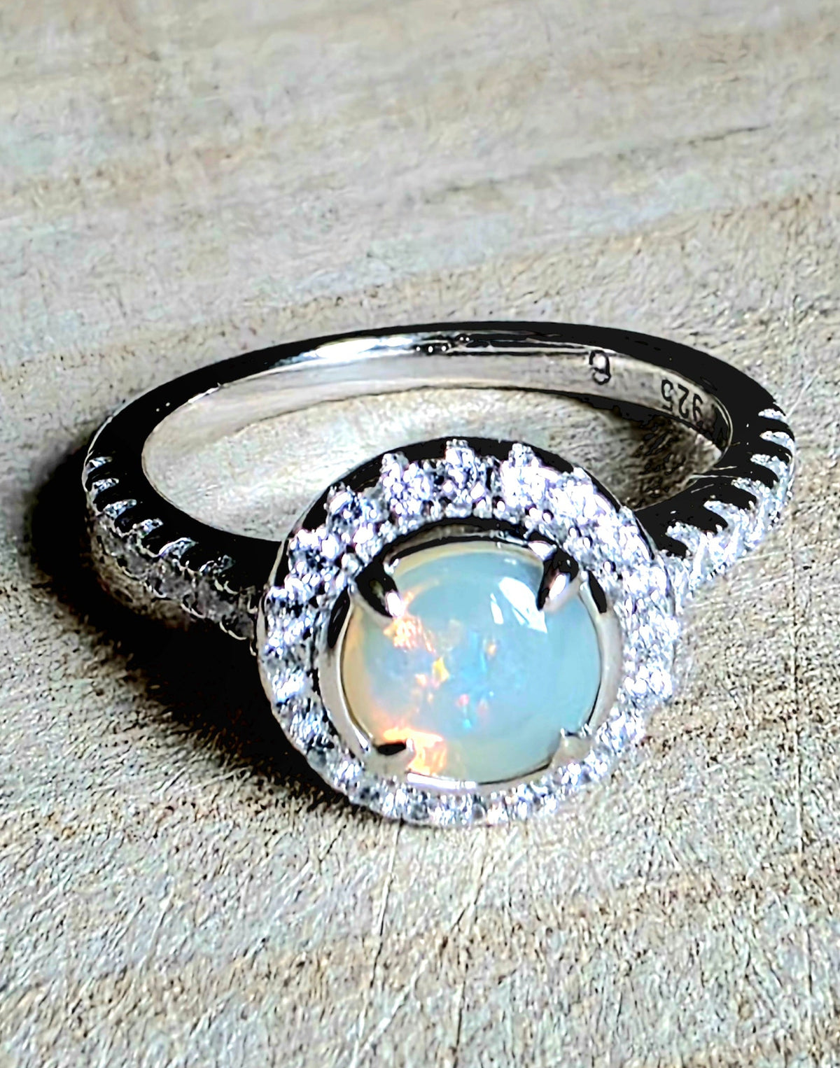 A crystal opal ring in a Princess Diana engagement ring format, with crystal accents and 925 setting