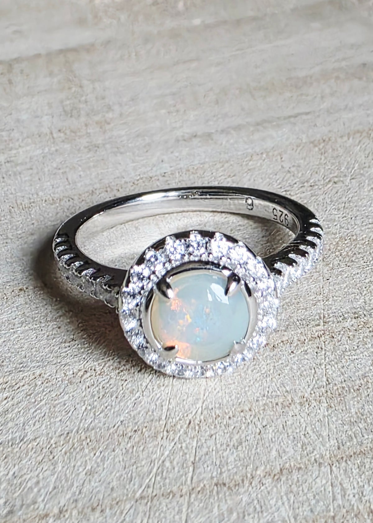 A crystal opal ring in a Princess Diana engagement ring format, with crystal accents and 925 silver setting