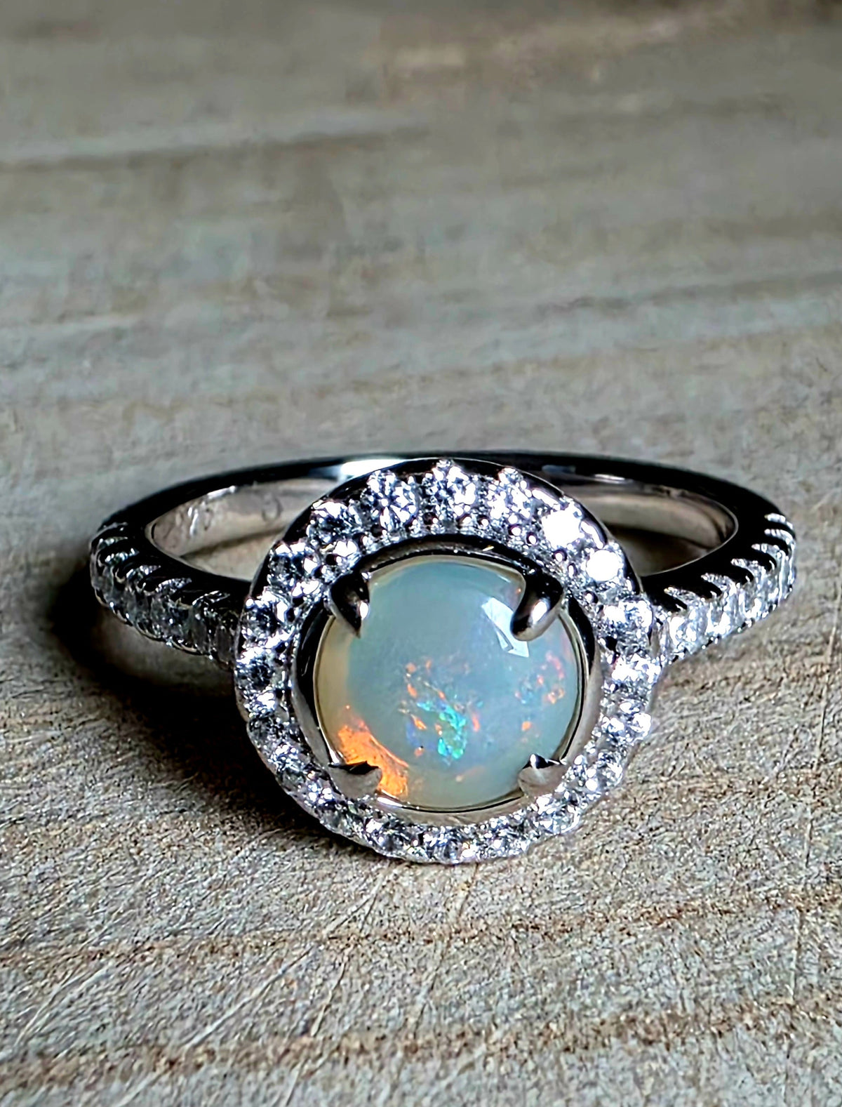 A crystal opal ring in a Princess Diana engagement ring format, with crystal accents in 925 setting