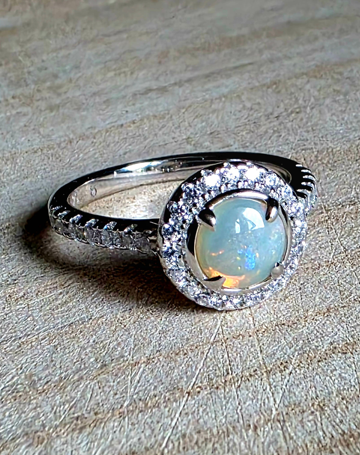 A crystal opal ring in a Princess Diana engagement ring format, with crystal accents and 925 setting