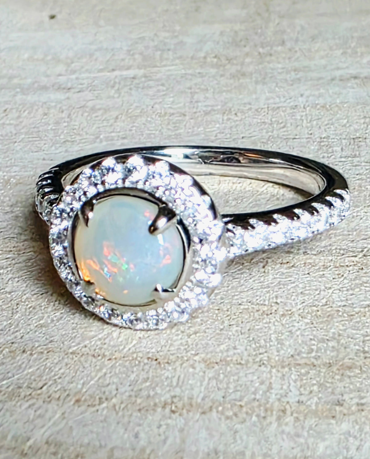 A crystal opal ring in a Princess Diana engagement ring format, with crystal accents, 925 setting